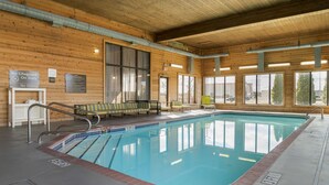 An indoor swimming pool with wooden walls, a lifeguard chair, and a bench. - Comfort Inn & Suites Toledo North (Toledo)