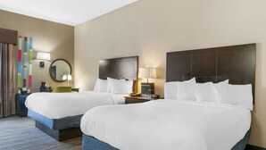 A hotel room with two beds, a large mirror, a nightstand with a lamp, and a wall with a colorful abstract design. - Comfort Inn & Suites Toledo North (Toledo)