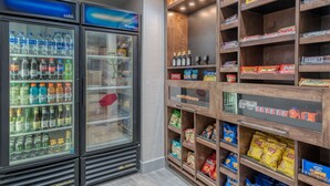 Ein Getränkeautomat mit verschiedenen Getränken und Snacks, darunter Coca-Cola, Pepsi und Lay's Chips.
