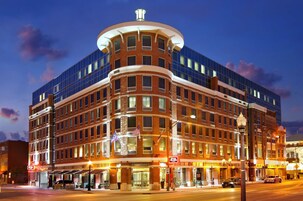 A multi-story hotel with a curved facade, large windows, and a central entrance.