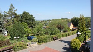A residential area with a paved road, a bench, and a car parked on the side. - Landhotel Dresden (Dresden)