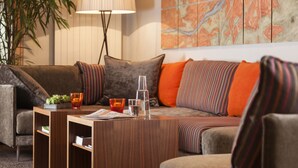 Un salon moderne avec un canapé, une table basse et une lampe.