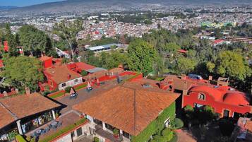 An aerial view of a town with red-roofed buildings, a prominent church, and a mountain in the background.