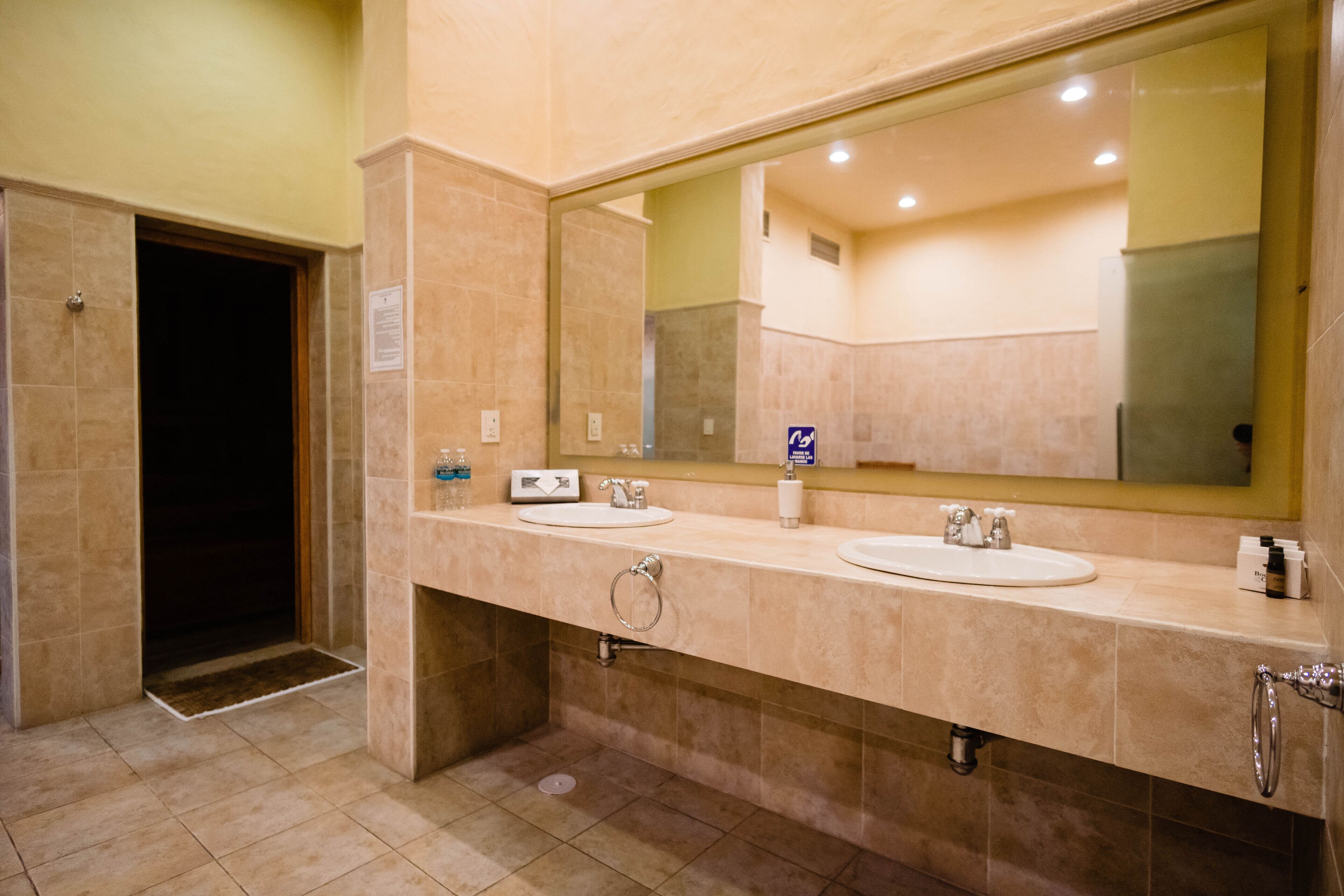 A bathroom with two sinks, a large mirror, and a towel rack.
