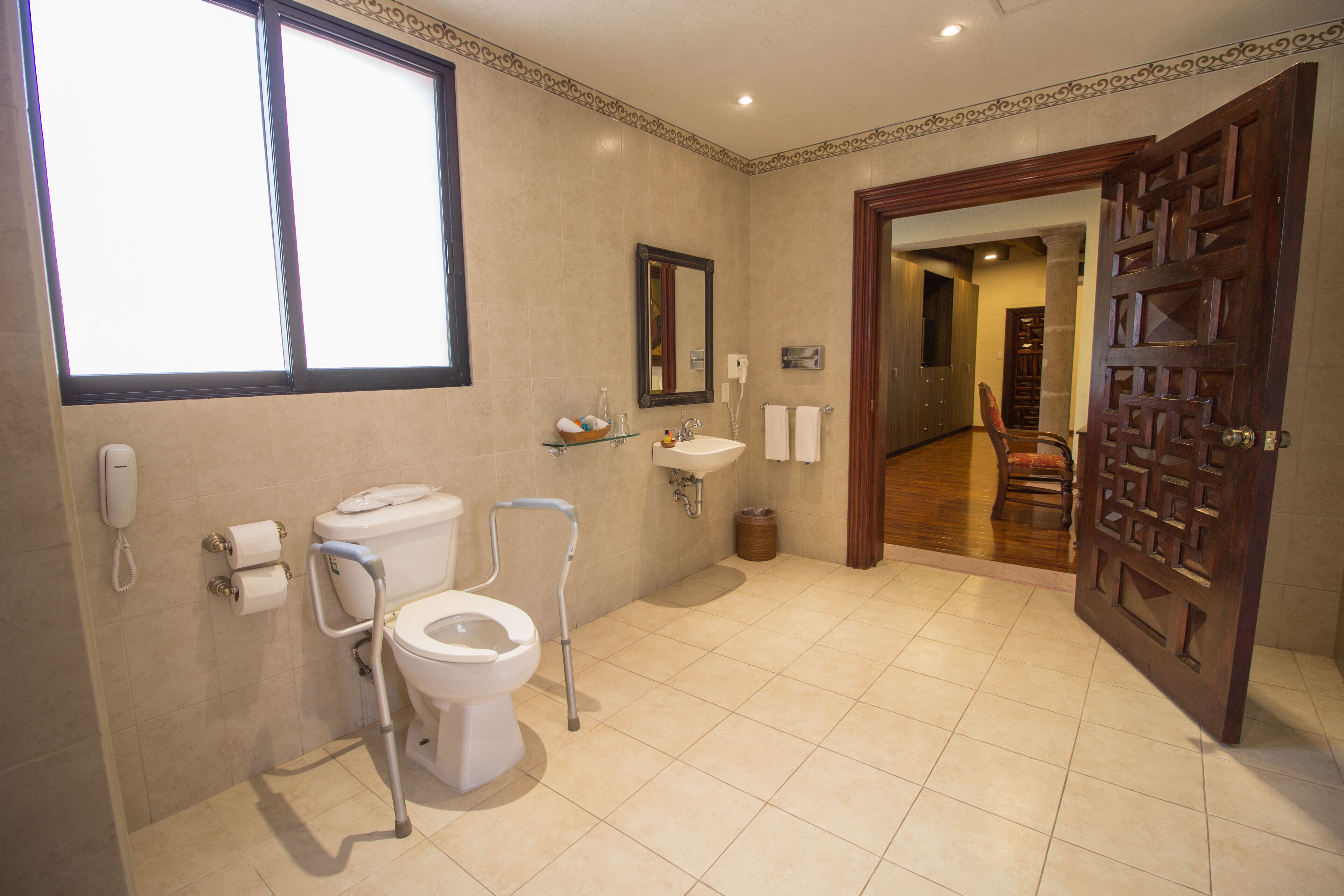 A bathroom with a toilet, bidet, sink, and a mirror.