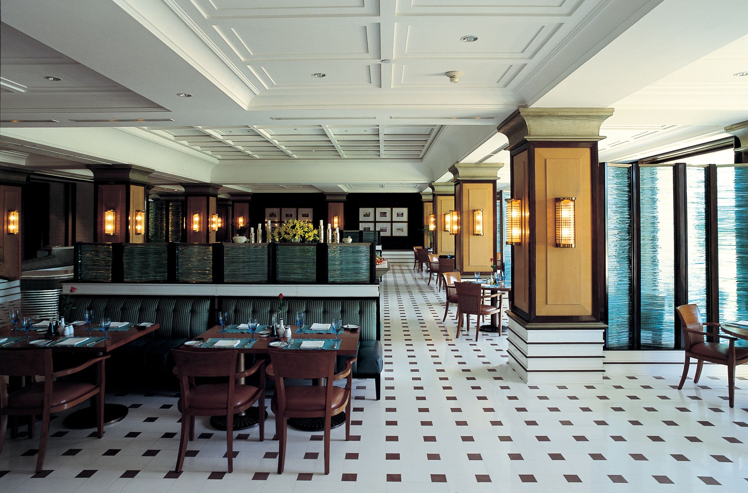 A restaurant with a checkered floor, wooden tables, and chairs.