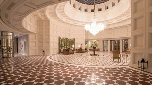 A spacious lobby with a checkered floor, a central chandelier, and a spiral staircase. - The Oberoi Amarvilas, Agra (Agra)