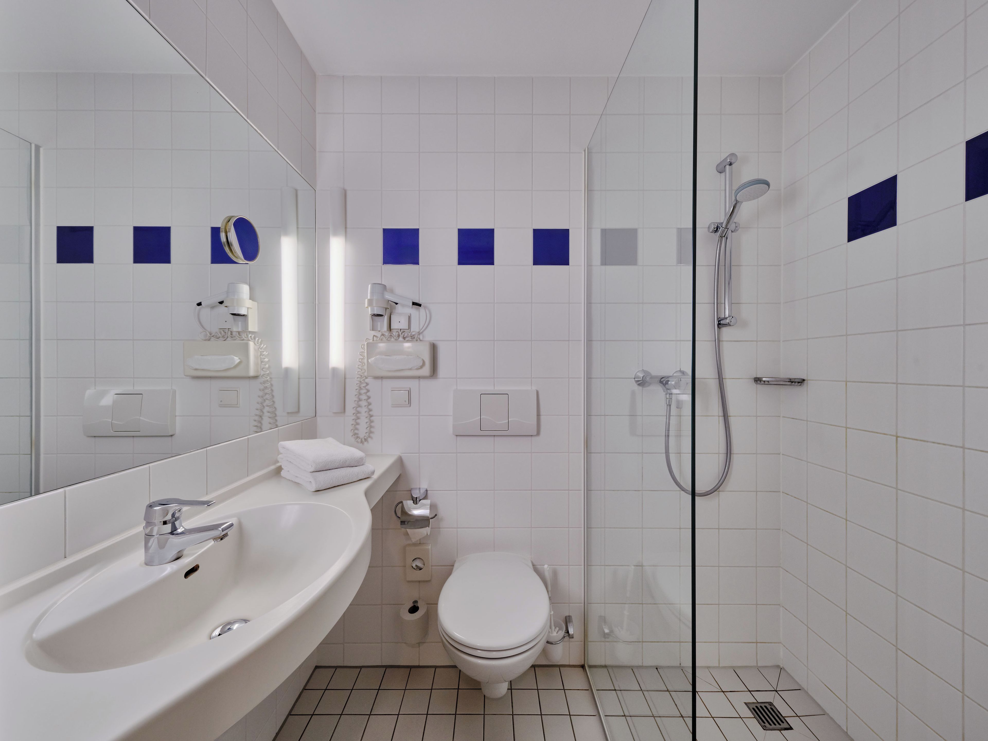 A modern bathroom with a sink, toilet, and shower.