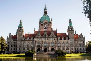 A historic building with a prominent clock tower, arched windows, and a central dome.