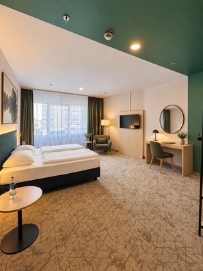A hotel room with a bed, desk, chair, and a TV. - YORS Hotel Hannover City Center (Hannover)