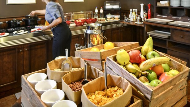Ein reichhaltiges Buffet mit verschiedenen Speisen und einer Person, die bedient.
