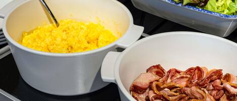 Three bowls of food on a stove.