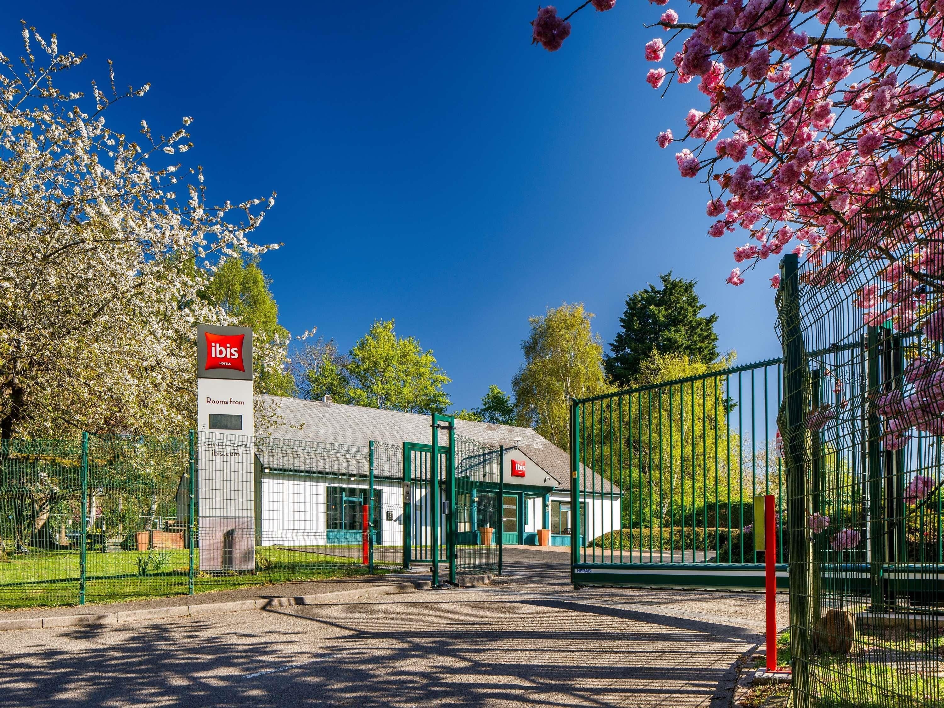 A hotel entrance with a sign indicating rooms from € and a website URL ibis.com.