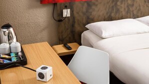 A hotel room with a bed, a desk with a laptop, a coffee maker, and a power strip. - ibis Coventry South (Coventry)