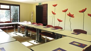 A classroom with tables and chairs, a window with blinds, and a door with a sign. - ibis Coventry South (Coventry)