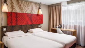 A hotel room with two beds, a desk, and a chair. - ibis Coventry South (Coventry)