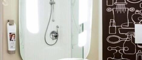 Ein Badezimmer mit einem großen Spiegel, einem Waschbecken und einer Dusche.