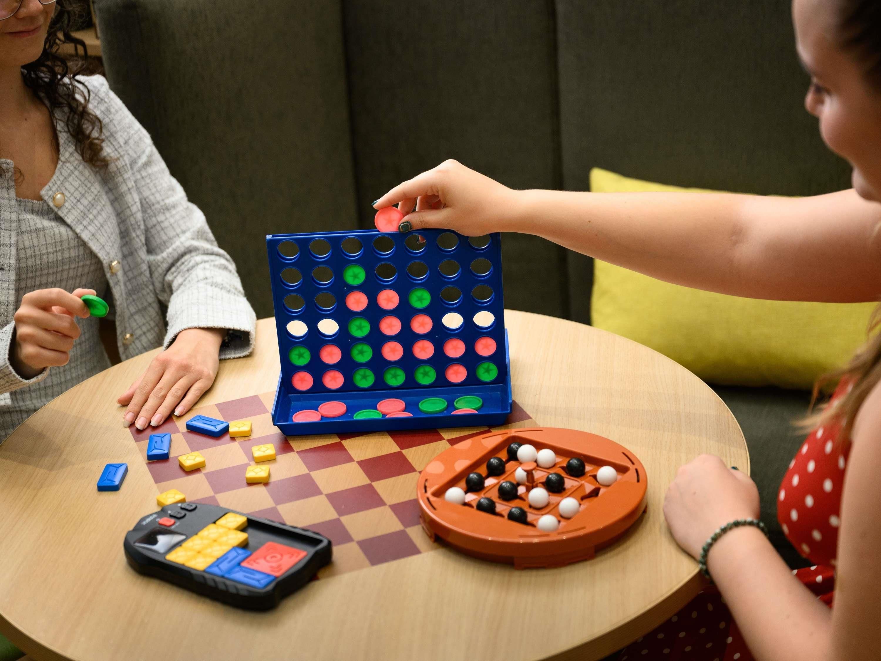 Una mesa redonda con un juego de mesa, damas y un juego de dados.