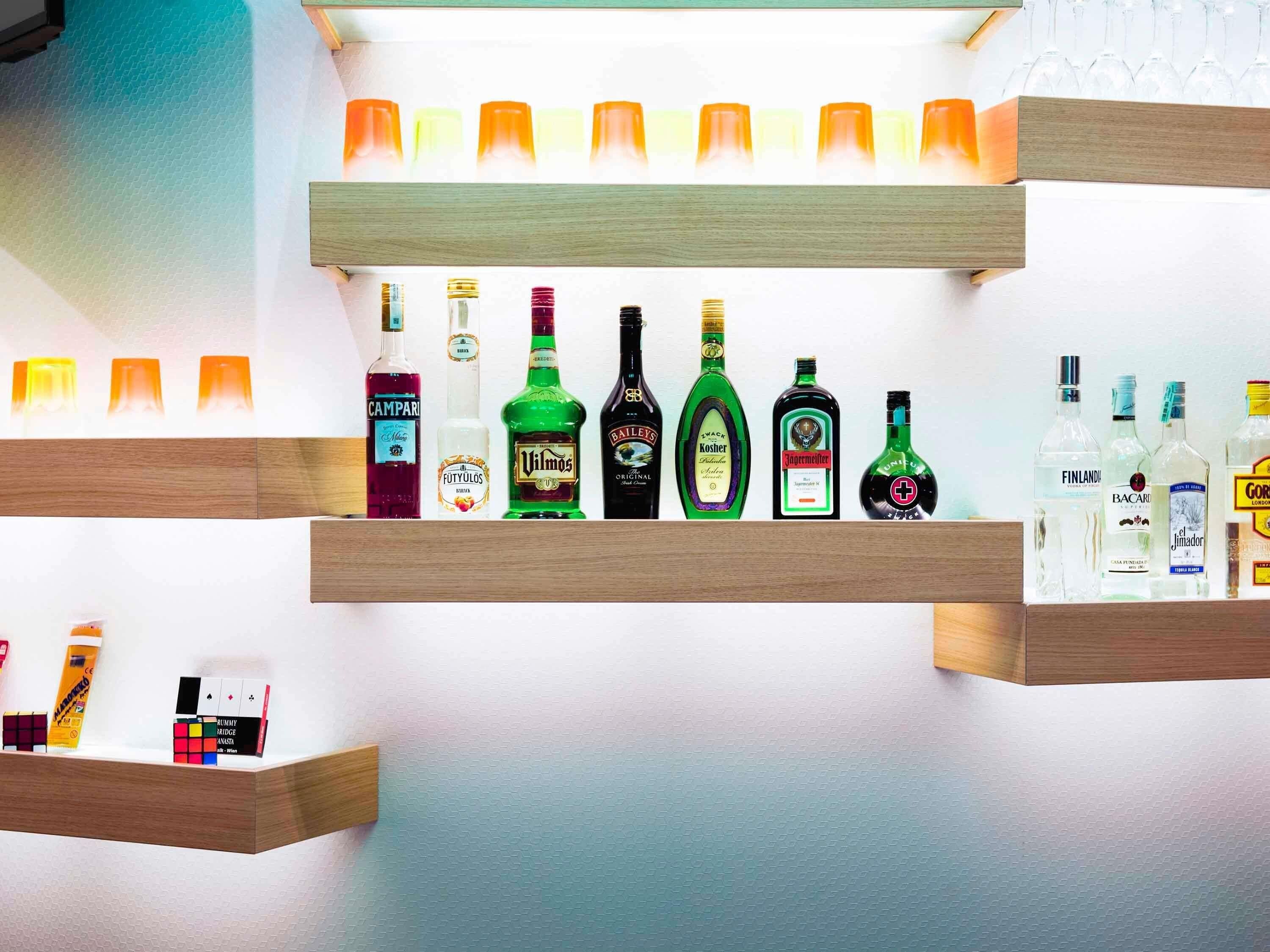 A bar area with shelves of various liquor bottles and glasses.