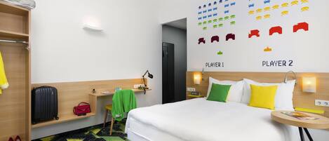 A hotel room with a bed, a desk, a chair, a wardrobe, and a wall with game icons.