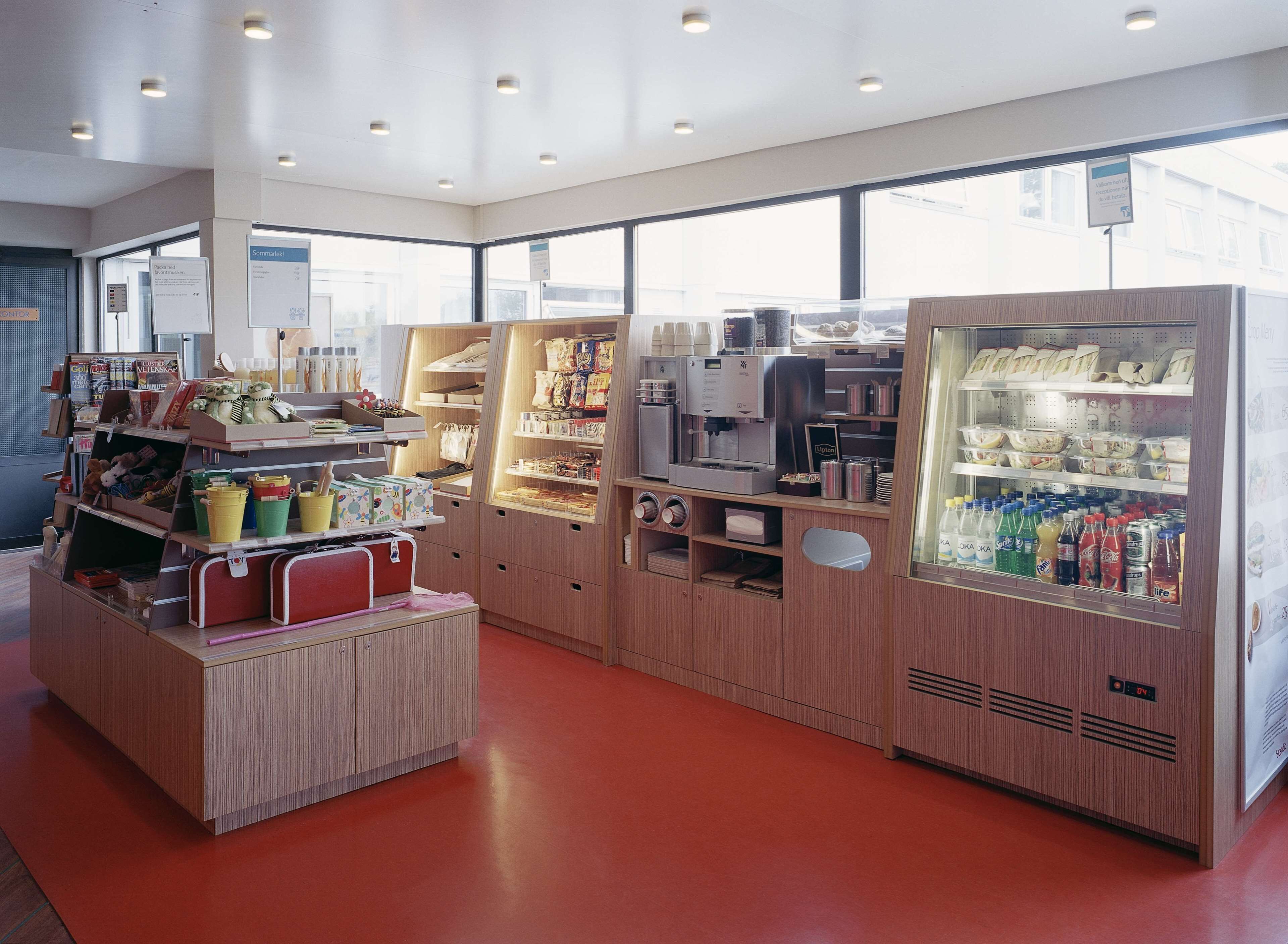 A modern coffee shop with a self-service counter, a variety of beverages, and a coffee machine.