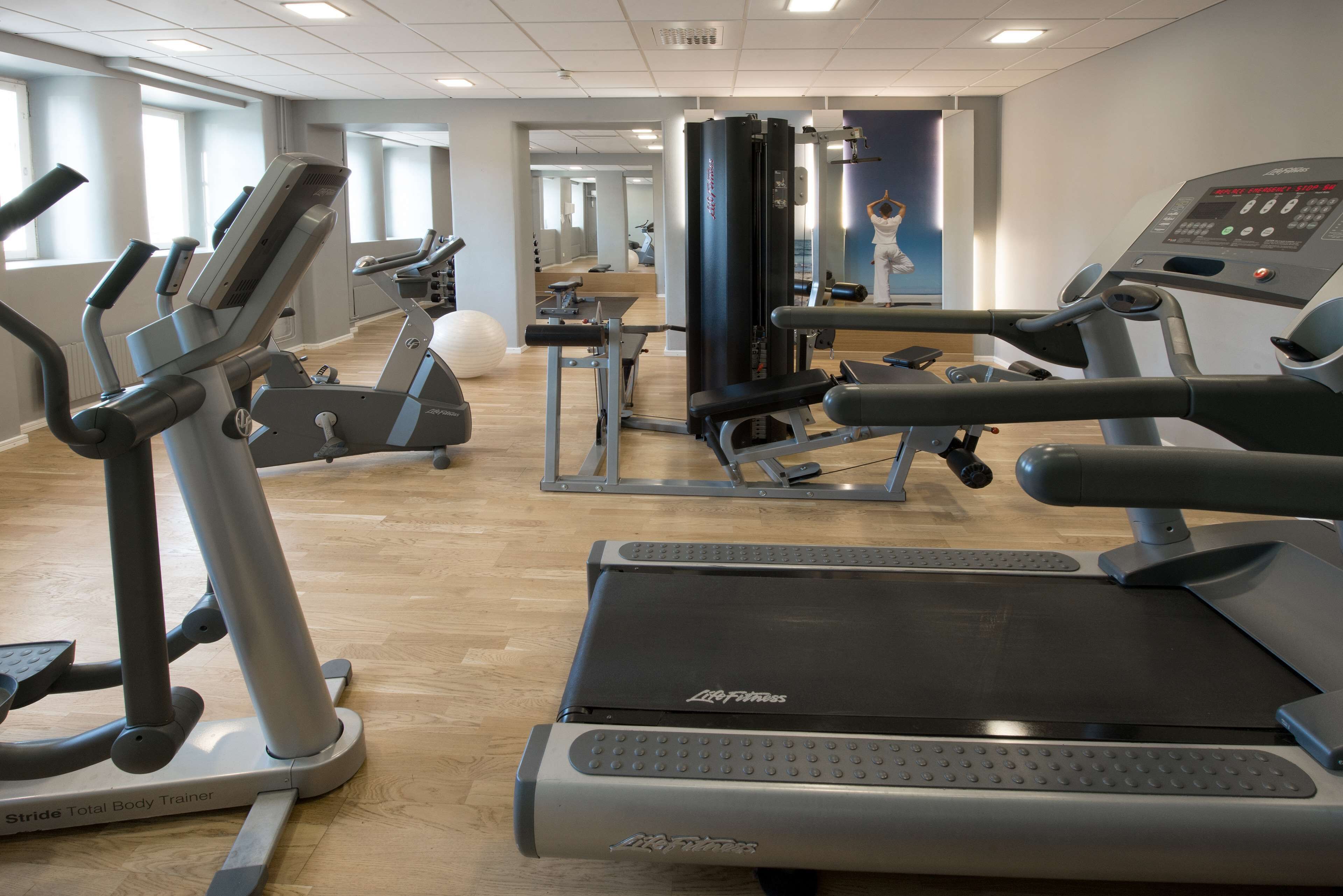 Ett gym med löpband, crosstrainers och en styrketräningsmaskin.