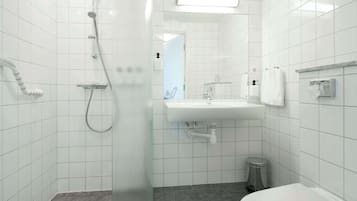 A modern bathroom with a shower, sink, and toilet.