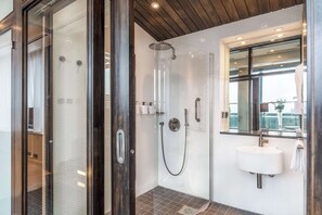 Enjoy a refreshing shower experience with a glass-enclosed shower, rain showerhead, and handheld showerhead.