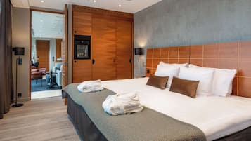 Une chambre d’hôtel avec un grand lit, une armoire en bois et une vue sur le couloir.
