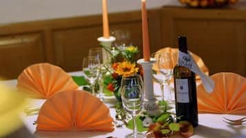 A table set for a meal with candles, wine, and decorative elements.
