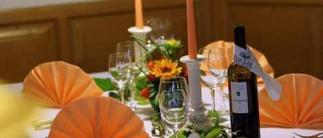 A table set for a meal with candles, wine, and decorative elements.