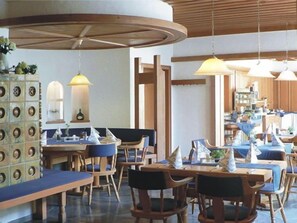 A restaurant with wooden furniture, pendant lighting, and a tiled floor. - Lamm Hotel & Restaurant (Hoechberg)