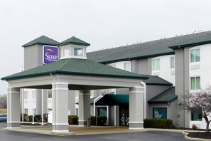 A Sleep Inn & Suites building with a covered entrance, multiple windows, and a sign on the roof. - Sleep Inn & Suites Oregon - Toledo (Oregon)