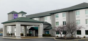 A Sleep Inn & Suites building with a covered entrance, multiple windows, and a sign on the roof. - Sleep Inn & Suites Oregon - Toledo (Oregon)