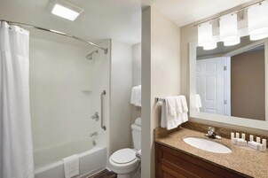 Un baño con ducha, inodoro y lavabo.