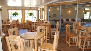 En restaurant med træmøbler og store vinduer.