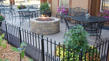 Relax by the fire pit surrounded by lush greenery and comfortable seating.