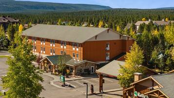 Ett stort hotell med flera byggnader, en parkeringsplats och en bergig bakgrund.