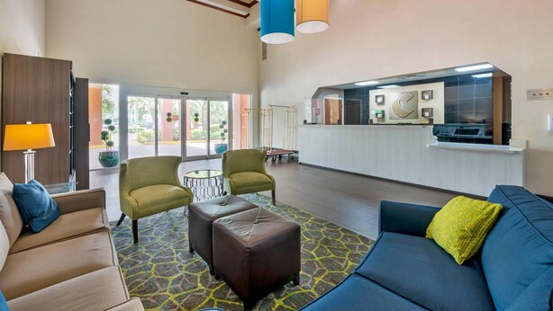 Un hall d’entrée spacieux, aménagé avec un canapé, des fauteuils, une table basse et un tapis à motifs.