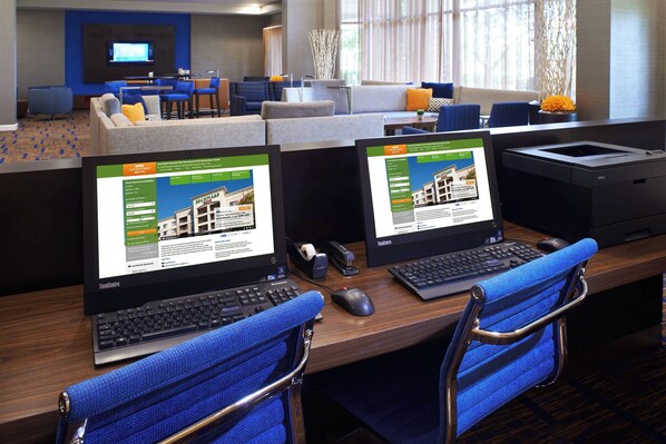A hotel lobby with a reception desk, seating area, and a large window.