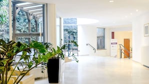Un hall d’entrée spacieux, doté d’une grande fenêtre, d’un escalier et d’un comptoir d’accueil.