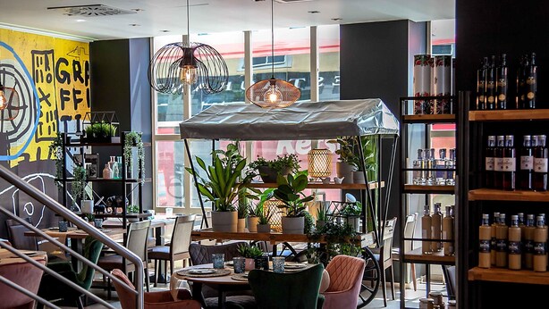 Un intérieur moderne comprenant un coin repas, des plantes en pot et un meuble à vin.