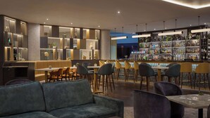 A modern bar area with seating and a well-stocked liquor shelf. - Hilton Cardiff (Cardiff)