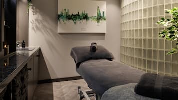 Et spa-rum med massagestol, bykunst og glasvæg.