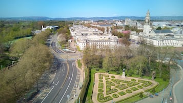 Vista aérea de un paisaje urbano que muestra un complejo de edificios destacado, una glorieta y un jardín ajardinado.