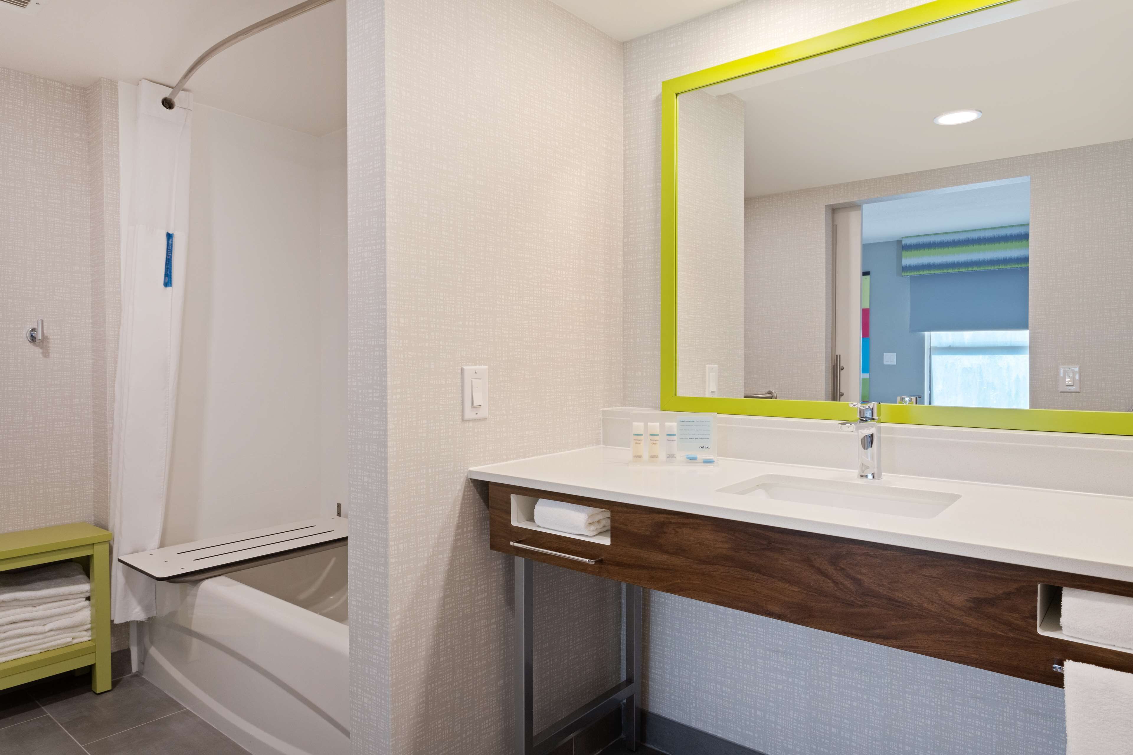 Une salle de bain moderne avec un lavabo blanc, un miroir et une douche.