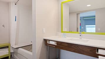 A modern bathroom with a white sink, mirror, and shower.