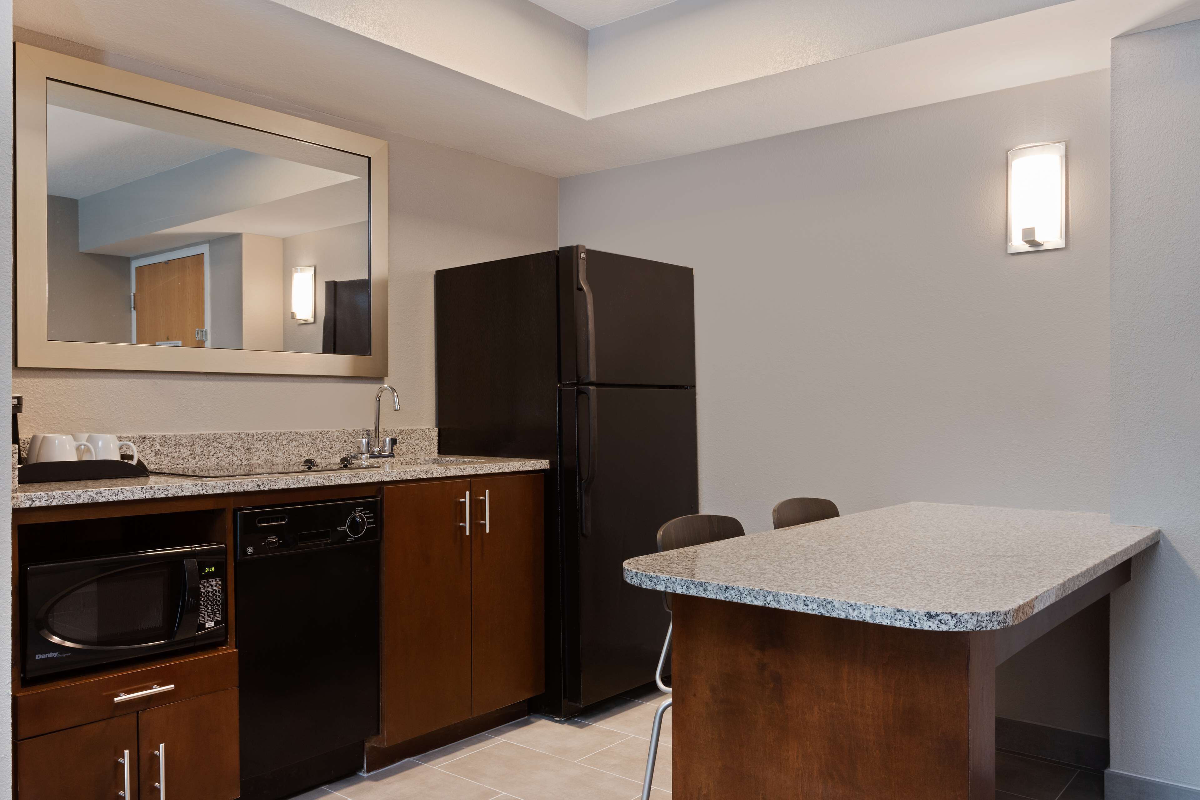 A compact kitchen with a microwave, dishwasher, and refrigerator.