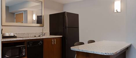 A compact kitchen with a microwave, dishwasher, and refrigerator.