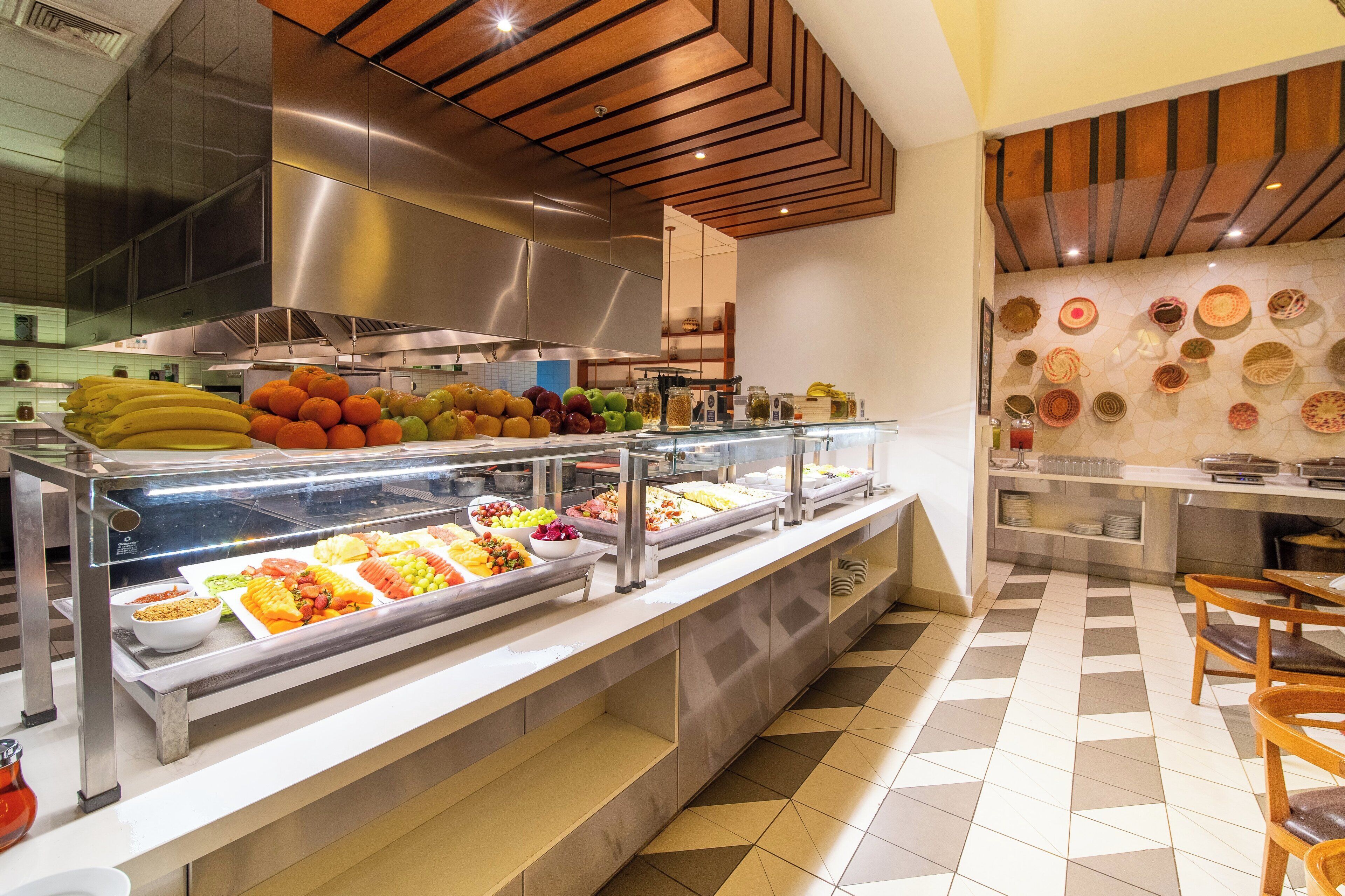 Zona de buffet con diversas frutas y verduras dispuestas en recipientes de vidrio.